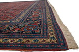 Angled view of a fine Tabriz carpet, detailing the wide turtle motif border and fringe.