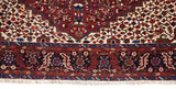 Finely knotted serrated leaf border in gem tones on a vintage Persian Karaja collector rug.