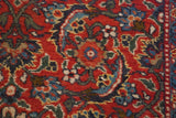 Intricate Herati motif woven in brick red, navy blue, and green wool pile.
