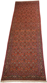 Long, angled view of a vintage Tabriz runner's allover Herati motif on a brick red field.