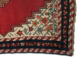 Stepped cherry red medallion and floral borders on the corner of an antique Karabagh collector rug.