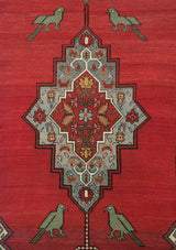 Central floral medallion with powder blue and gold, flanked by stylized green birds on a cochineal red field.