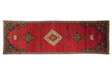 Antique Karabagh runner with a medallion column and green pictorial birds on a vibrant cochineal red field.
