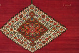 Colorful floral details within the main stepped diamond medallion of an antique Karabagh rug.