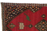 Green bird motif and navy floral spandrel on the rich red field of an antique Karabagh rug.
