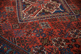 Close-up of the Joshegan rug's intricate red field and blue reciprocating pawn border.