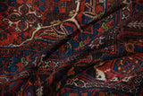Joshegan carpet's deep brick red, sapphire blue pile with arabesque palmette design.