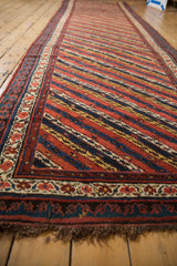 Long perspective view of an antique Kurdish runner highlighting its diagonal vine pattern.