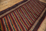 Angled view of the repeating diagonal vine and channel pattern on an antique Kurdish runner.