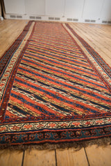 Angled view of the full antique Kurdish runner, highlighting the repeating diagonal channel design.