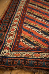 The bold pawn motif border and colorful diagonal stripes of an antique Kurdish runner rug.