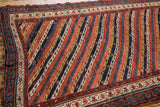 Corner of an antique Kurdish rug showing the intact side cord selvage and reciprocating pawn motif border.