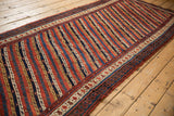 A full length perspective of the antique Kurdish runner's intricate parallel vine design.