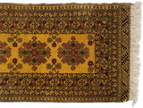 Corner of a vintage Daulatabad runner showing geometric medallions in gold, charcoal, and raspberry red.