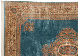 Corner of vintage Kerman carpet with intact fringe and intricate floral border.