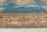 Kerman carpet with intricate floral beige border, soft blue field, and white fringe.