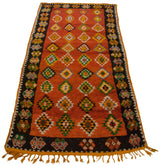 Full length angled view of a vintage Moroccan runner with repeating colorful diamond motifs.
