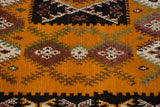 Close-up of the full saffron yellow pile with geometric germinating plant motifs.