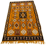 Angled view of a vintage Moroccan runner with a saffron yellow field and geometric medallions.