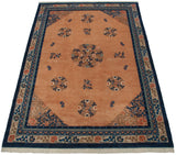 Vintage Peking carpet corner with pale apricot field, cobalt blue medallions, bats, and geometric border.
