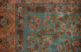 Corner detail of a vintage Kerman carpet showing the peach border and sky blue millefleur field.