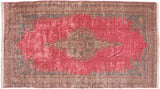 Oversized vintage Kerman carpet with a floral medallion and blue spandrels on a vast, rich pink field.