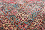 Angled view of the full wool pile on a Kerman carpet's slate blue corner spandrel.