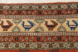 Hand-knotted vintage Meshkin rug detail: playful terracotta, sapphire blue birds, pale seafoam border.