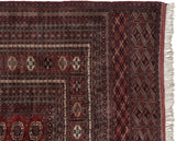 Finely woven corner of a Pakistani Bokhara carpet with gul medallions and original side cord selvage.