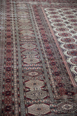 Detailed view of the fine layered borders next to the repeating gul motifs on the ivory field.