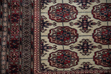 Intricate layered borders in red and navy alongside the repeating floral gul motifs.