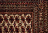 Finely woven corner of a Bokhara carpet with repeating gul medallions and detailed geometric borders.