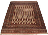 An angled view displaying the luster and repeating gul pattern of a fine vintage Pakistani Bokhara carpet.