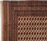 Intricate geometric borders and original selvage on the corner of a vintage Pakistani Bokhara carpet.