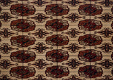 Finely knotted gul medallions in terra cotta and navy on a plush, full ivory wool pile.
