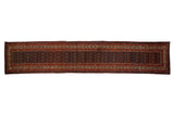 Vintage Hamadan rug runner with staggered boteh designs on a navy blue field surrounded by rust and ivory borders.