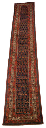 Angled view of a long vintage Hamadan runner, displaying rows of boteh designs on a navy field.