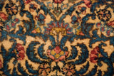 Close-up of the dense, full pile showing stylized millefleur sprays in blue, red, and gold.