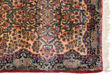 A vintage Kerman's plush pile, navy floral border, intact red side cord, and fringe.