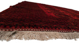 Low angle view of the vintage Ersari carpet's deep red full pile and original natural fringe.