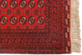 Corner of a vintage Daulatabad rug showing its repeating gul motif, Tekke borders, and ivory fringe.
