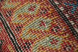 Fine, even pile and hand-knotted structure of a Persian Fereghan in red, gold, and green.
