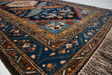 Ardebil rug corner featuring bird motifs on deep blue, geometric borders, and natural fringe.