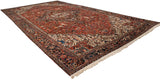 Angled full view of a vintage Mehrivan carpet with a red medallion field and navy border.