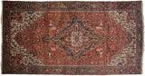 Intricate vinery and serrated leaves covering the brick red field of a vintage Mehrivan Persian carpet.