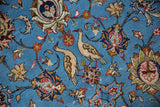 A pair of beige birds and floral palmettes on the sky blue field of a vintage Persian Qom carpet.
