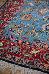 Finely detailed tiger and bird motifs at the corner of a hand-knotted vintage Qom carpet.