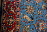 A vintage Qom rug's pictorial detail showing a deer, birds, and leopards in red and blue.