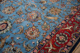 Angled view of a vintage Qom carpet's pictorial design with a deer, palmettes, and a red animal border.