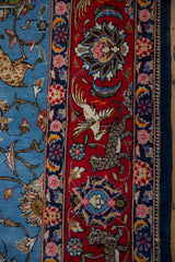 Pictorial border detail of a vintage Persian Qom carpet with a hand-knotted tiger and bird on red.